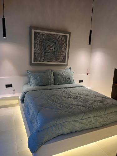 a bedroom with a large bed with a painting on the wall at Villa Semoga in Tanjung