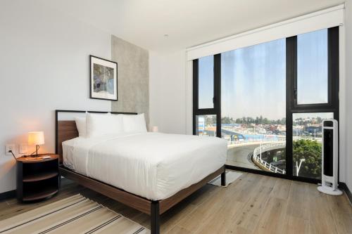 a bedroom with a bed and a large window at Amazing Apartments in the Heart of Interlomas in Mexico City