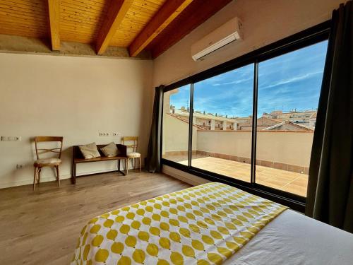 a bedroom with a bed and a large window at CASA EN EL CENTRO DE CALELLA A 300 m DE LA PLAYA in Calella