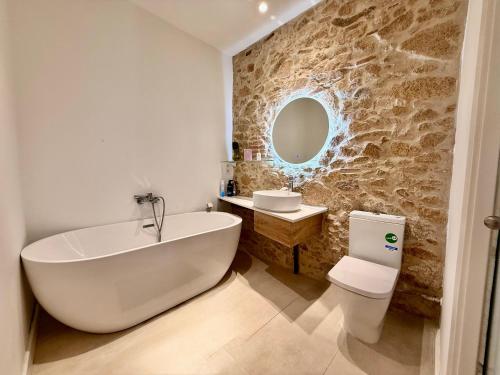 a bathroom with a tub and a toilet and a sink at CASA EN EL CENTRO DE CALELLA A 300 m DE LA PLAYA in Calella