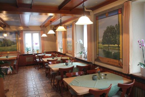 a dining room with tables and chairs and windows at Gasthaus Zur Sonne in Freiburg im Breisgau
