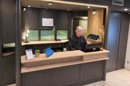 a man sitting at a counter with a laptop at Hotel Punt 14 Barcelona Gavà Mar in Gavà