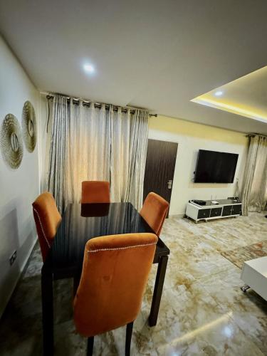 a dining room table and chairs in a living room at Abuja Circa Suite in Abuja
