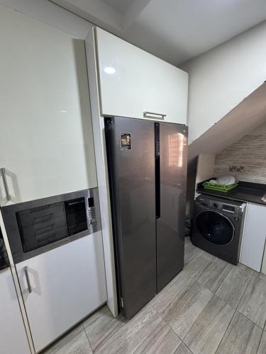 a kitchen with a refrigerator and a microwave at Abuja Circa Suite in Abuja