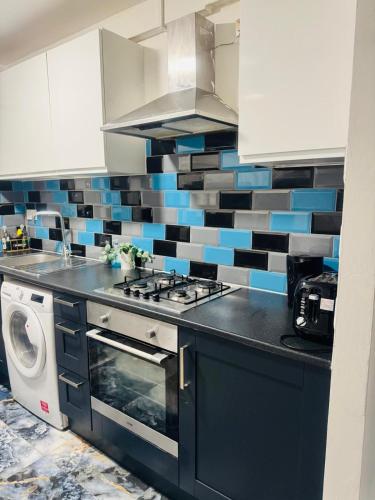 a kitchen with a stove and a washing machine at East London Suites 1 in London