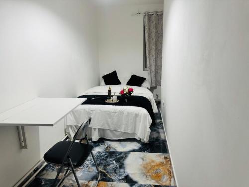 a bedroom with a bed and a table and chairs at East London Suites 1 in London