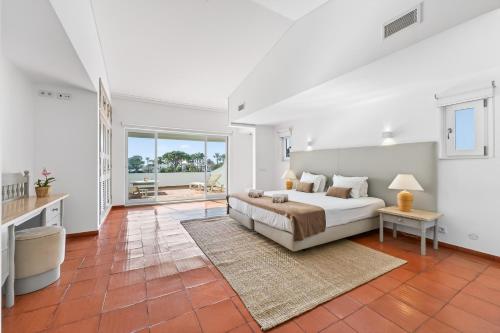 a large bedroom with a bed and a table at Casa Mimosa by Algarve Holidays in Vale do Lobo