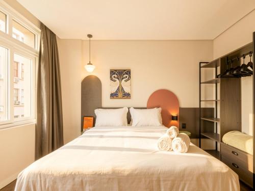 a bedroom with a large bed with towels on it at Xtay Cais Rooftop -Estúdios completos e Rooftop para o Rio Guaíba in Porto Alegre