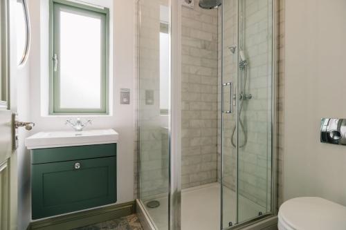 a bathroom with a shower and a sink at The Tractor Shed in Combrook