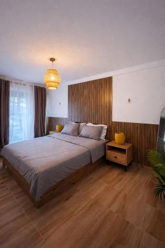 a bedroom with a large bed and a chandelier at Bega's BDuplex in Golem, Durrës in Golem