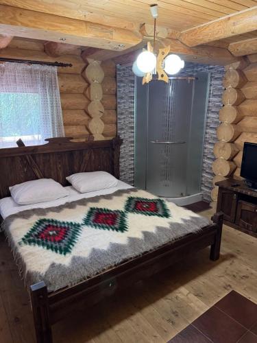 a bedroom with a bed in a log cabin at Бистриця in Chynadiyovo
