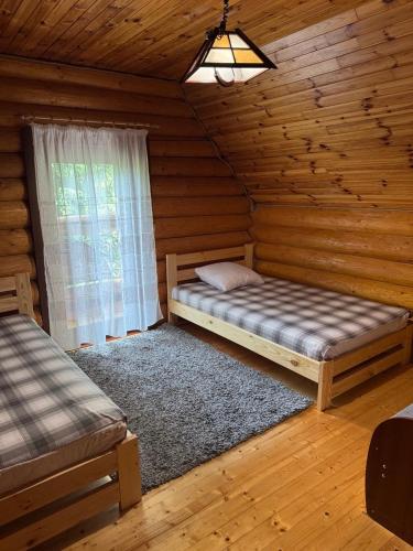 a bedroom with a bed in a log cabin at Бистриця in Chynadiyovo