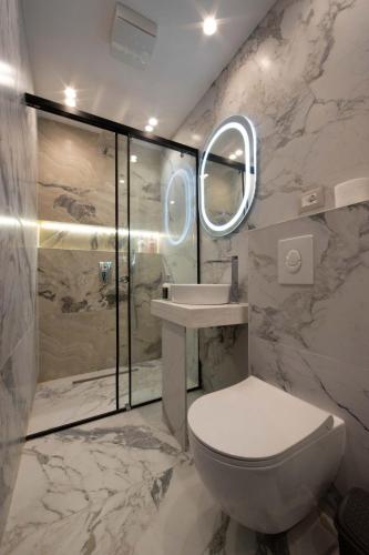a bathroom with a toilet and a sink and a shower at Bliss Modern Retreat in Tirana