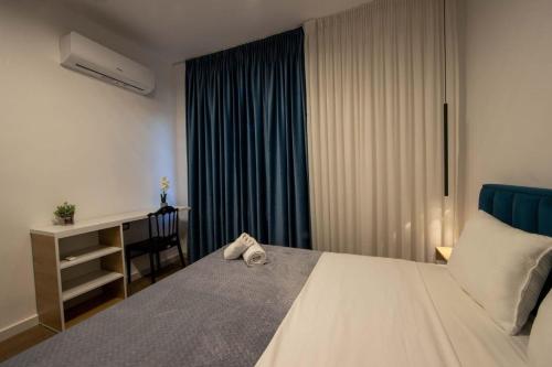a bedroom with a bed with a desk and a window at Bliss Modern Retreat in Tirana