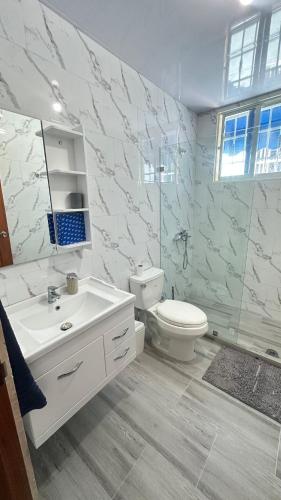 a bathroom with a white sink and a toilet at Green House Boca Chica in El Higo
