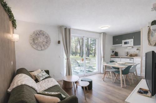 a living room with a couch and a table at Le Trésor du Lac - Casteljaloux - Lac de Clarens - Appartement - Piscine - Parking - WIFI - Accès privée Plage - Golf - Casino - Terra Aventura - So Vélo in Casteljaloux
