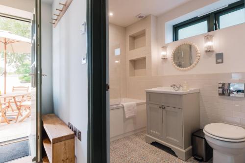 a bathroom with a toilet and a sink and a tub at The Old Workshop, Combrook in Combrook