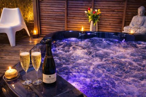 a hot tub with two glasses of champagne at Les Suites du Littoral in Plouézec