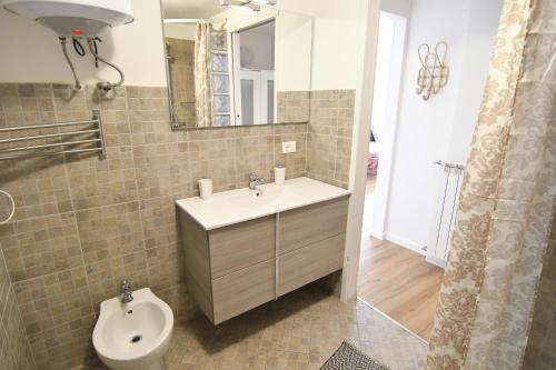 a bathroom with a sink and a toilet and a mirror at Alla Cantina in Aurisina Case