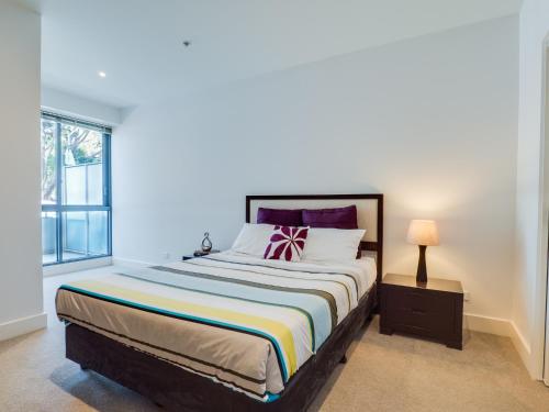 Un dormitorio con una cama grande y una ventana en Waterfront (Yarra St) by Gold Star Stays en Geelong
