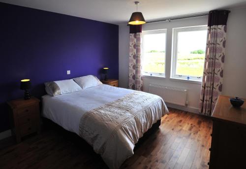 a bedroom with a large bed and a window at Hartaval & Baca Ruadh in Staffin