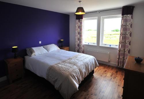 um quarto com uma cama grande e uma janela em Hartaval & Baca Ruadh em Staffin