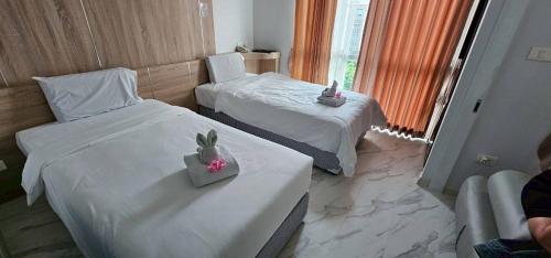 a hotel room with two beds and a window at Condo D-Eco Wellness Center A8721 in North Pattaya