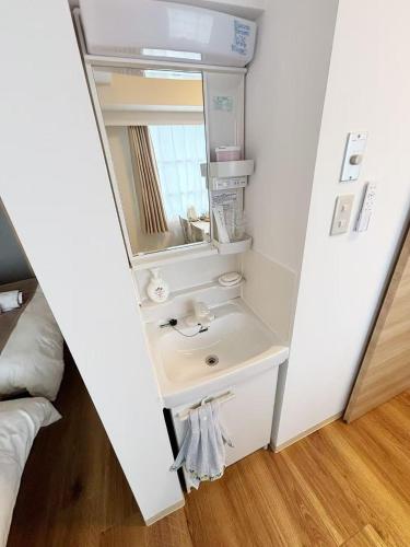 a bathroom with a sink and a mirror at Lucky民泊 in Osaka