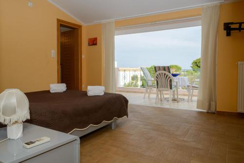 a bedroom with a bed and a view of a patio at Athenian Spiti in Artemida