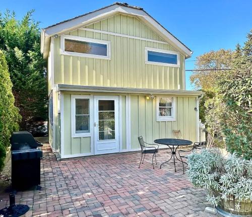 a house with a patio with a table and chairs at Seabreeze #3 - Cozy cottage by the beach in Hampton Bays