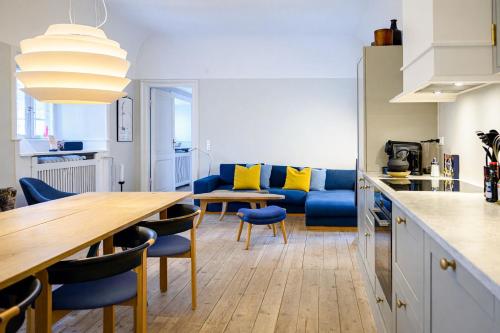 a kitchen and living room with a table and a couch at Holsteins Palace Luxury Apartment in Copenhagen