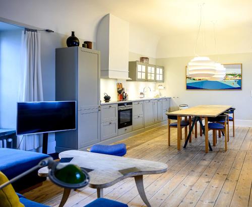 a kitchen and living room with a table and a dining room at Holsteins Palace Luxury Apartment in Copenhagen