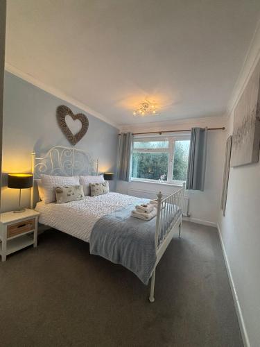 a bedroom with a bed with a heart on the wall at Alverstoke Manor - family home with pool table in Alverstoke