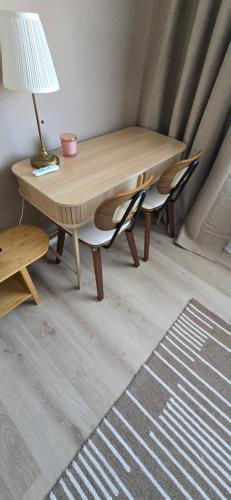 a wooden table with two chairs and a lamp on it at Twickenham and West Middlesex Rooms Isleworth Stay in Isleworth