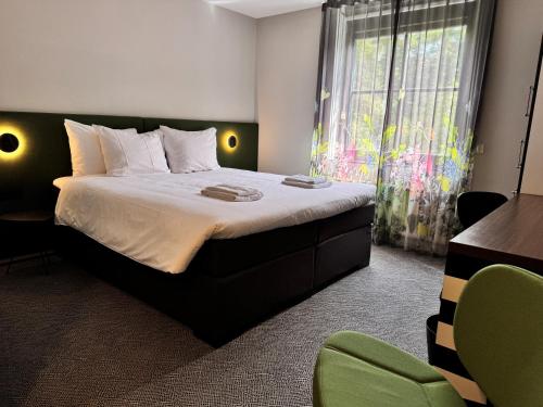 a bedroom with a large bed and a window at Hotel Kapellerput Heeze-Eindhoven in Heeze