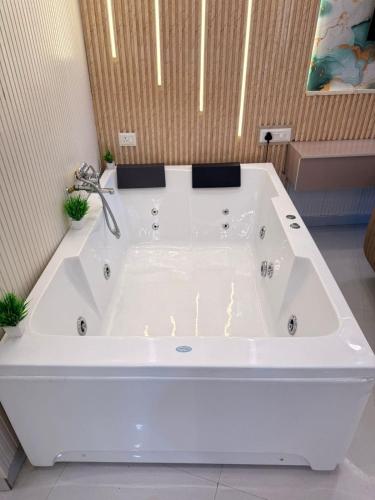 a large white bath tub in a bathroom at Luxury Jacuzzi Studio -Couple Friendly- Noida in Ghaziabad