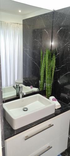 a bathroom with a white sink and a mirror at Villa Palace Fernandes with Jacuzzi in Calheta