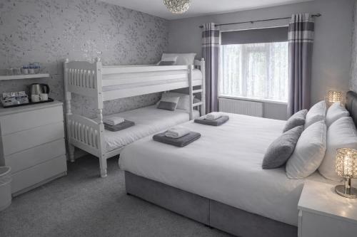 a bedroom with two bunk beds and a window at The Roslyn Guest House in Paignton