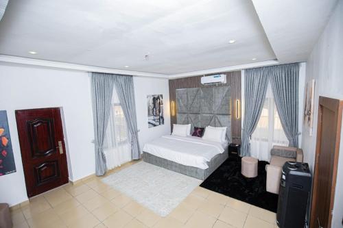 a bedroom with a white bed and two windows at The Kitchen Kabinet in Abuja