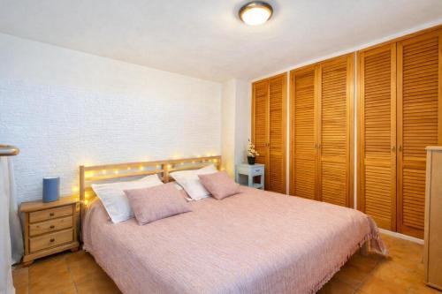 a bedroom with a bed and wooden cabinets at Cala Paradiso in Tossa de Mar