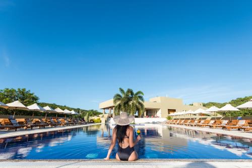 a woman sitting in the pool at a resort at Hotel Waya Guajira By OxoHotel in Albania