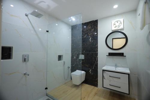 a bathroom with a shower and a sink and a mirror at Dee Cottage kanyakumari in Kanyakumari