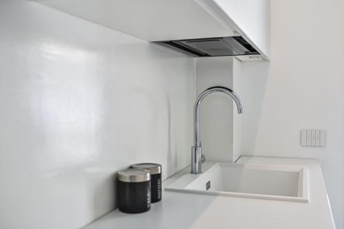 a white kitchen with a sink and a faucet at Villa Gioia con piscina privata in Marina di Ragusa