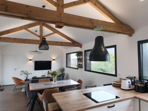 a kitchen and living room with wooden beams at Les Suites du Littoral in Plouézec