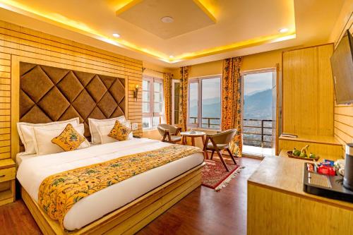 a hotel room with a large bed and a desk at Hotel Peak Paradise Resorts in Pahalgām