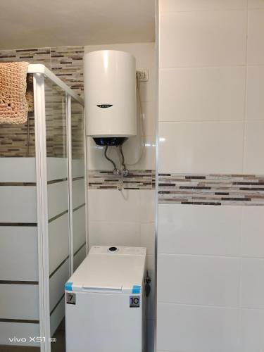 a small kitchen with a white refrigerator and a light at The beach nest in Candelaria