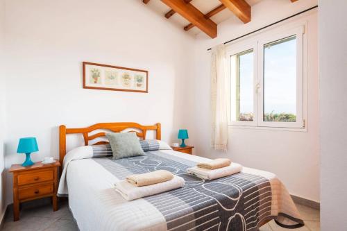 a bedroom with a bed with two towels on it at Villa Maru II by Villa Plus in Cala en Porter