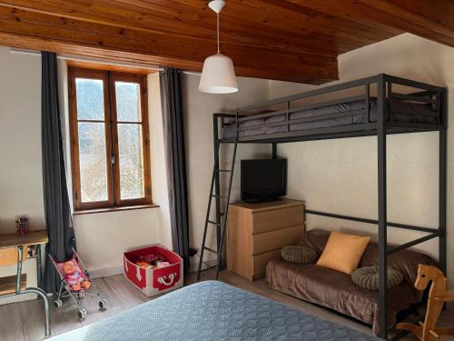 a bedroom with a bunk bed and a television at Chez Julie in Valleraugue