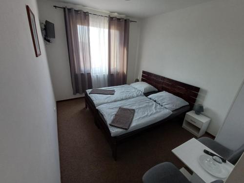 a small bedroom with a bed and a window at Apartmány ARIES in Nitra