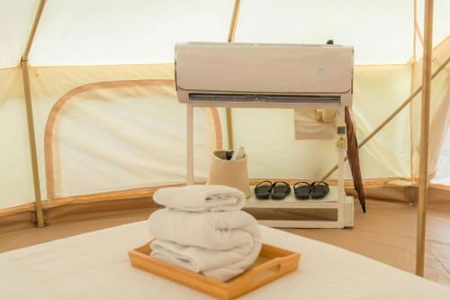 a pile of towels on a table in a tent at Wisdom Park Pattaya near Tomorrowland Thailand in Ban Khao Mai Kaeo
